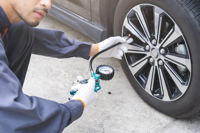 Technician checking tire pressure